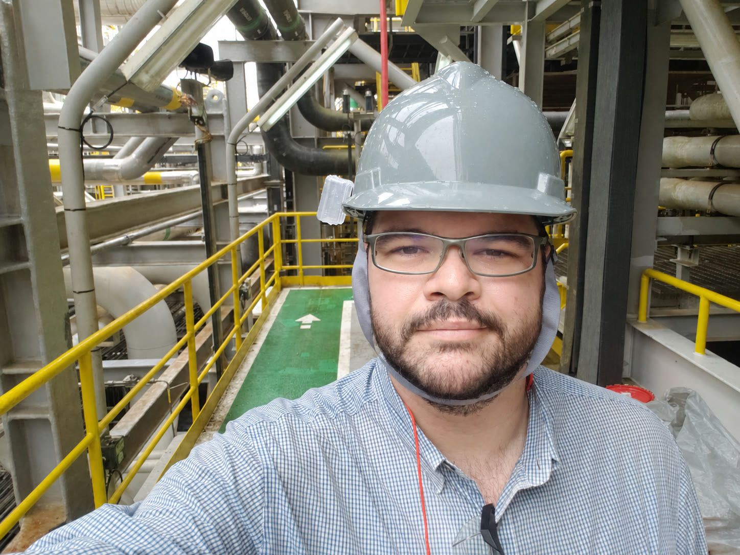 Pablo em campo, com equipamento de proteção, dentro de uma planta industrial