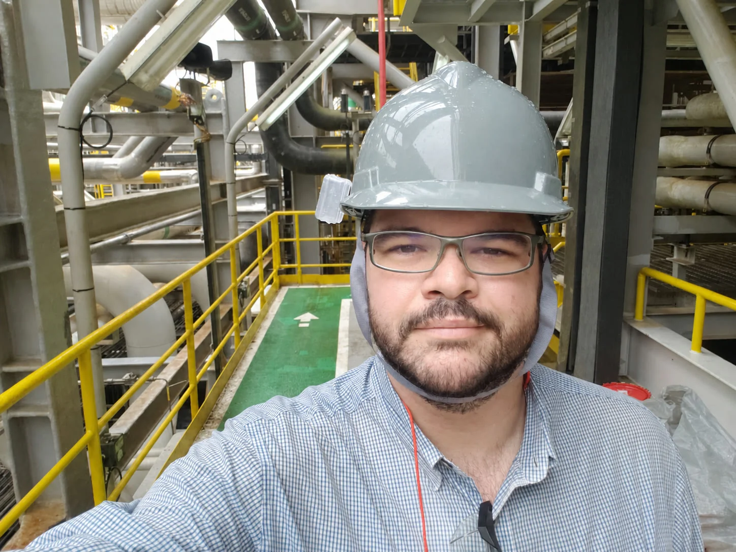 Pablo em campo, com equipamento de proteção, dentro de uma planta industrial